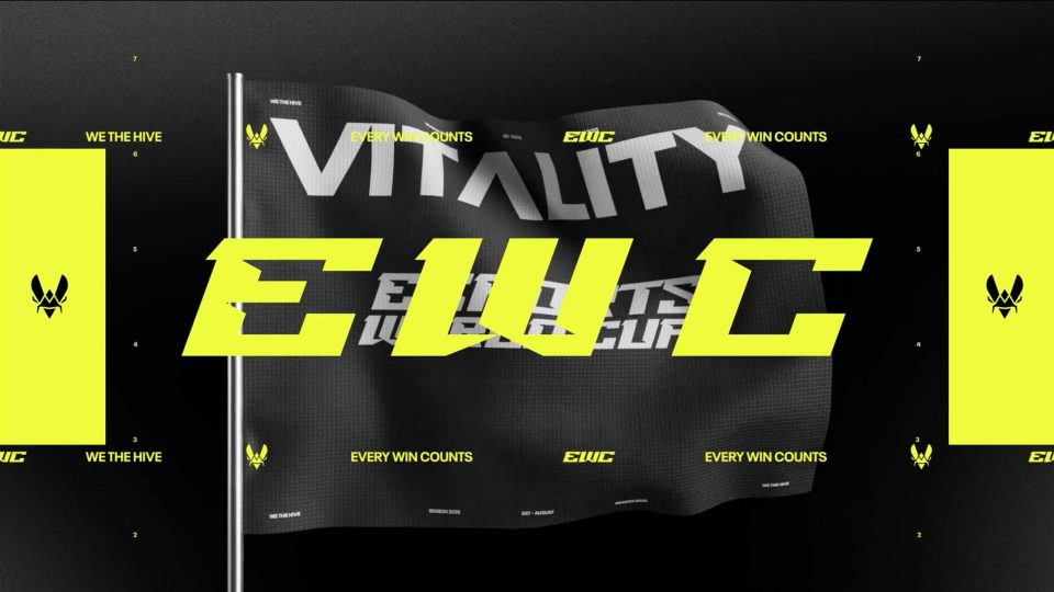 A flag featuring “VITALITY” in white and bold yellow letters “EWC” over it, inspired by NŌBL VITALITY. Smaller text reads “EVERY WIN COUNTS,” with winged logos throughout in a black, white, and yellow palette.