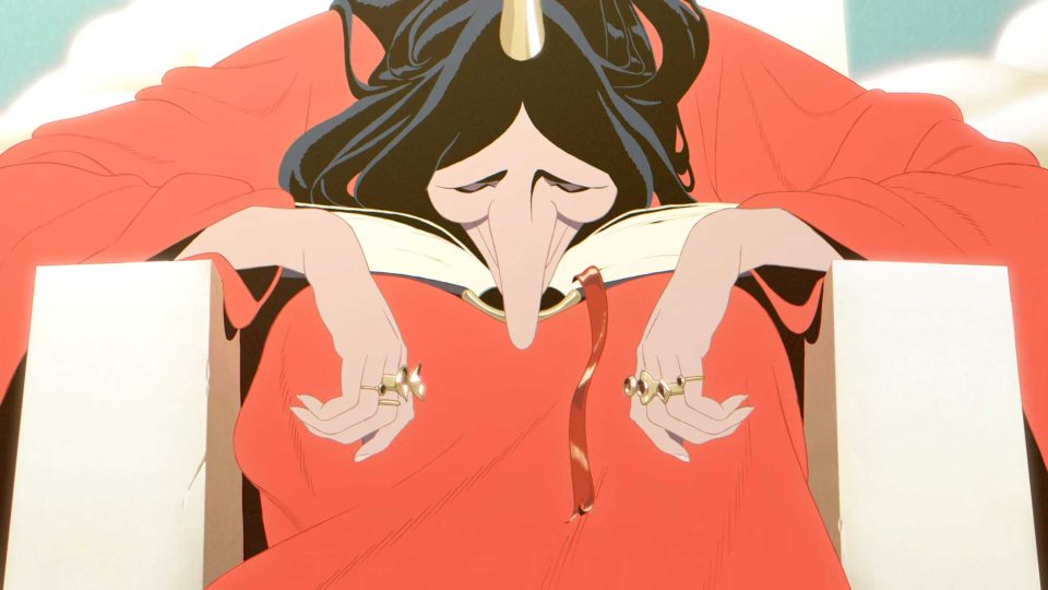 A person with dark hair and a gold horn sits in a red robe, resting their head on an open book held by their hands in the music video for Belle. Frame from Stash Magazine article.