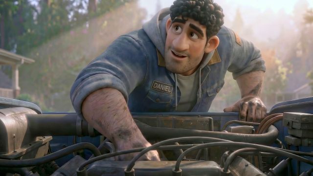 A smiling animated man with curly dark hair and a stubbly beard, wearing a blue denim jacket labeled Daniel, works under the hood of a vehicle outdoors in daylight—like putting his heart out to dry after laundry day. Frame from Stash Magazine article.